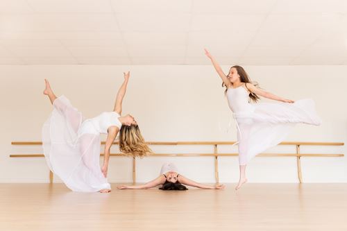 Dancers in tutus performing a modern ballet routine.