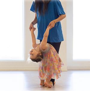 Enfant danseuse en position acrobatique avec instructrice à l'École de Danse Rachel Jasmin.